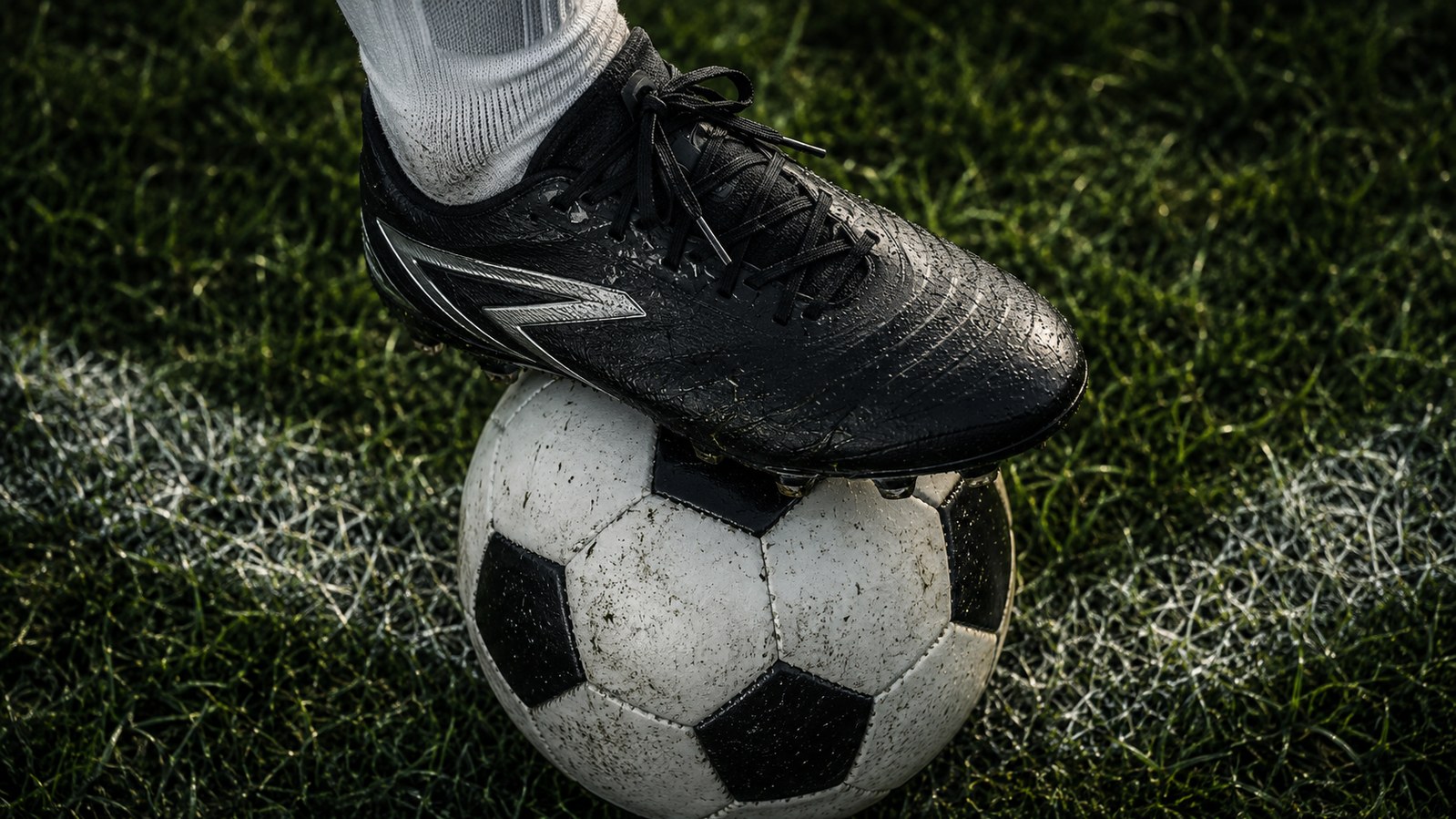 Botín negro sobre un balón de fútbol en una cancha, imagen ilustrativa de la eliminación de Alemania ante Paraguay