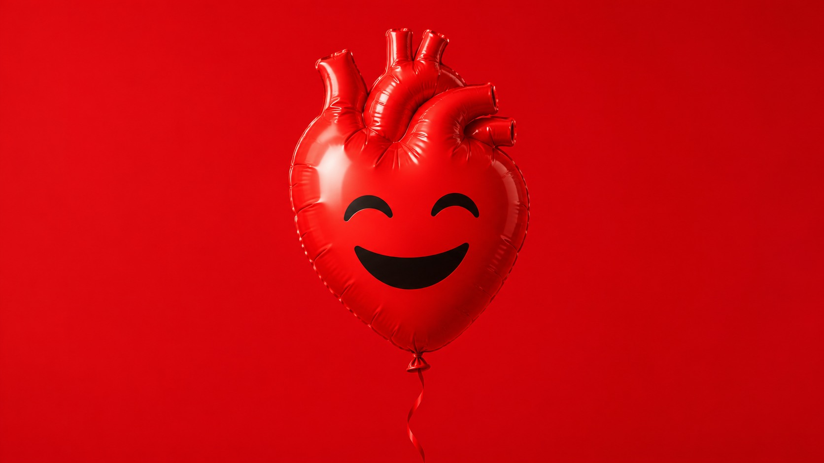 Globo rojo brillante con forma de corazón anatómico y una expresión sonriente sobre un fondo rojo