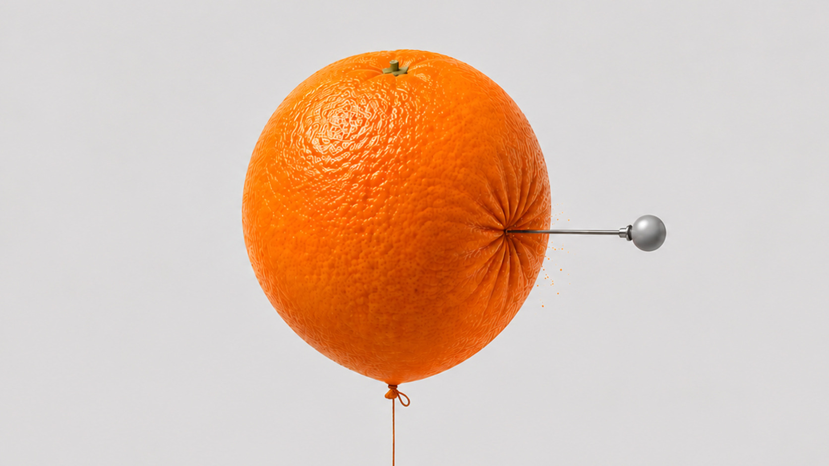 Naranja con forma de globo pinchada por un alfiler, representando el mito de la vitamina C y los resfriados